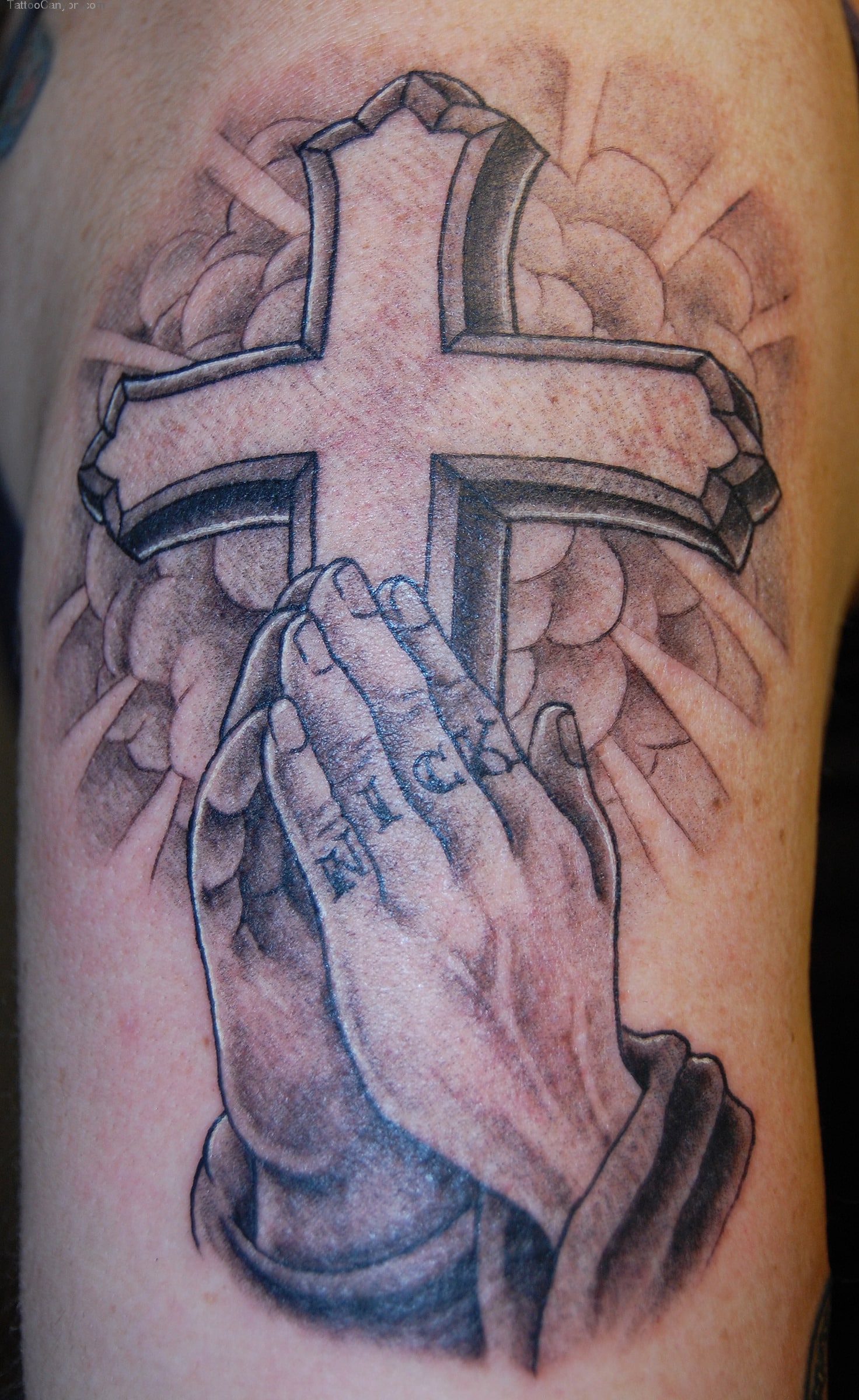 christian cross with praying hands tattoo